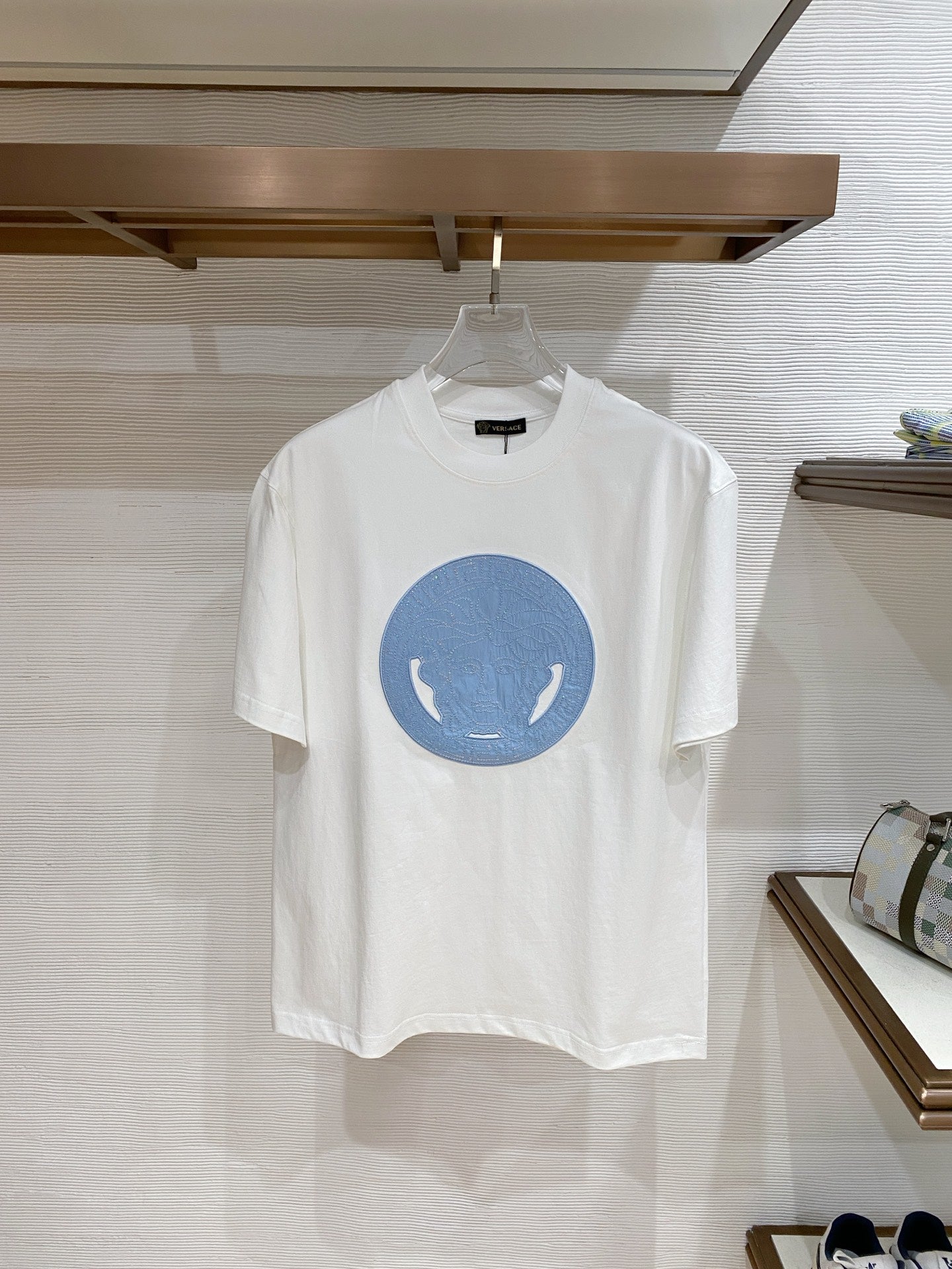 Versace T-shirt in white with blue circular horse graphic on the front.