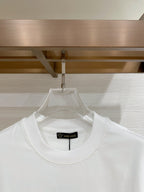 Versace T-shirt with crew neck and black neck label on white fabric.