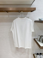 Versace T-shirt in white, hanging on a store rack.