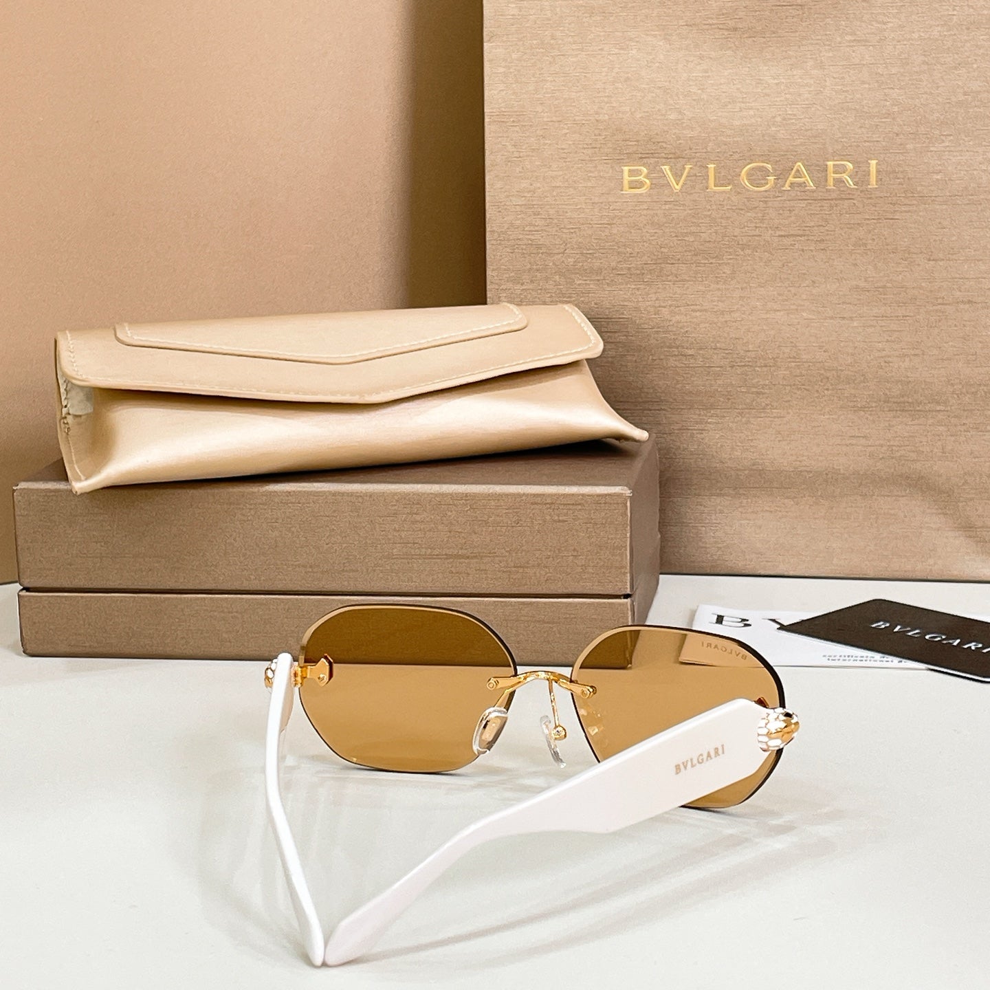 Round sunglasses with gold-tone frame and amber lenses with white temple