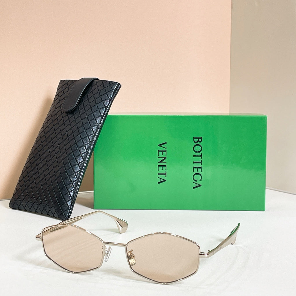 Sunglasses with beige lenses and gold-tone frames, shown with black textured case