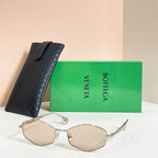 Sunglasses with beige lenses and gold-tone frames, shown with black textured case
