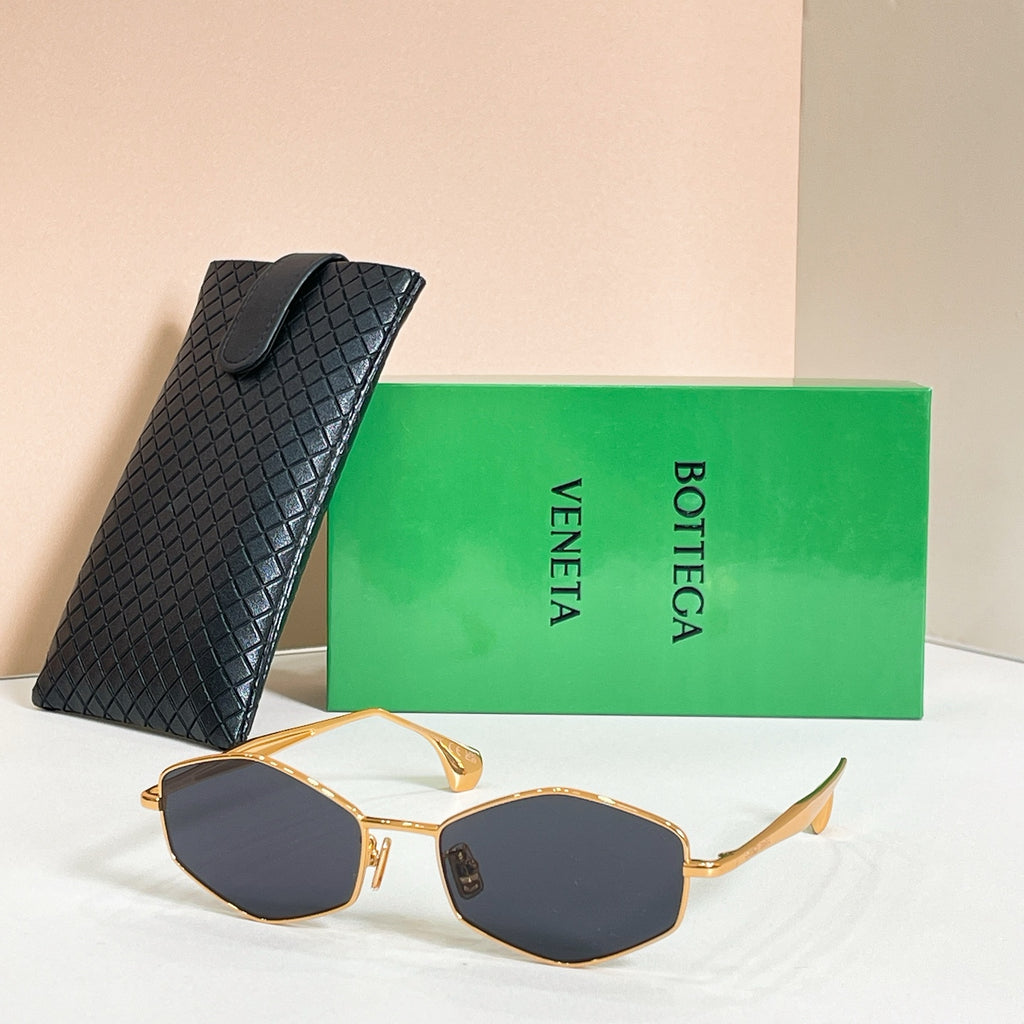 Sunglasses with dark lenses and gold-tone frames, side view with black textured case