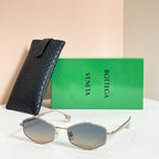 Sunglasses with beige lenses and gold-tone frames, shown with black textured case