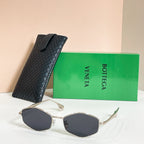 Sunglasses with dark lenses and gold-tone frames, shown with black textured case