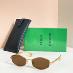 Sunglasses with brown lenses and gold-tone frames, shown with black textured case