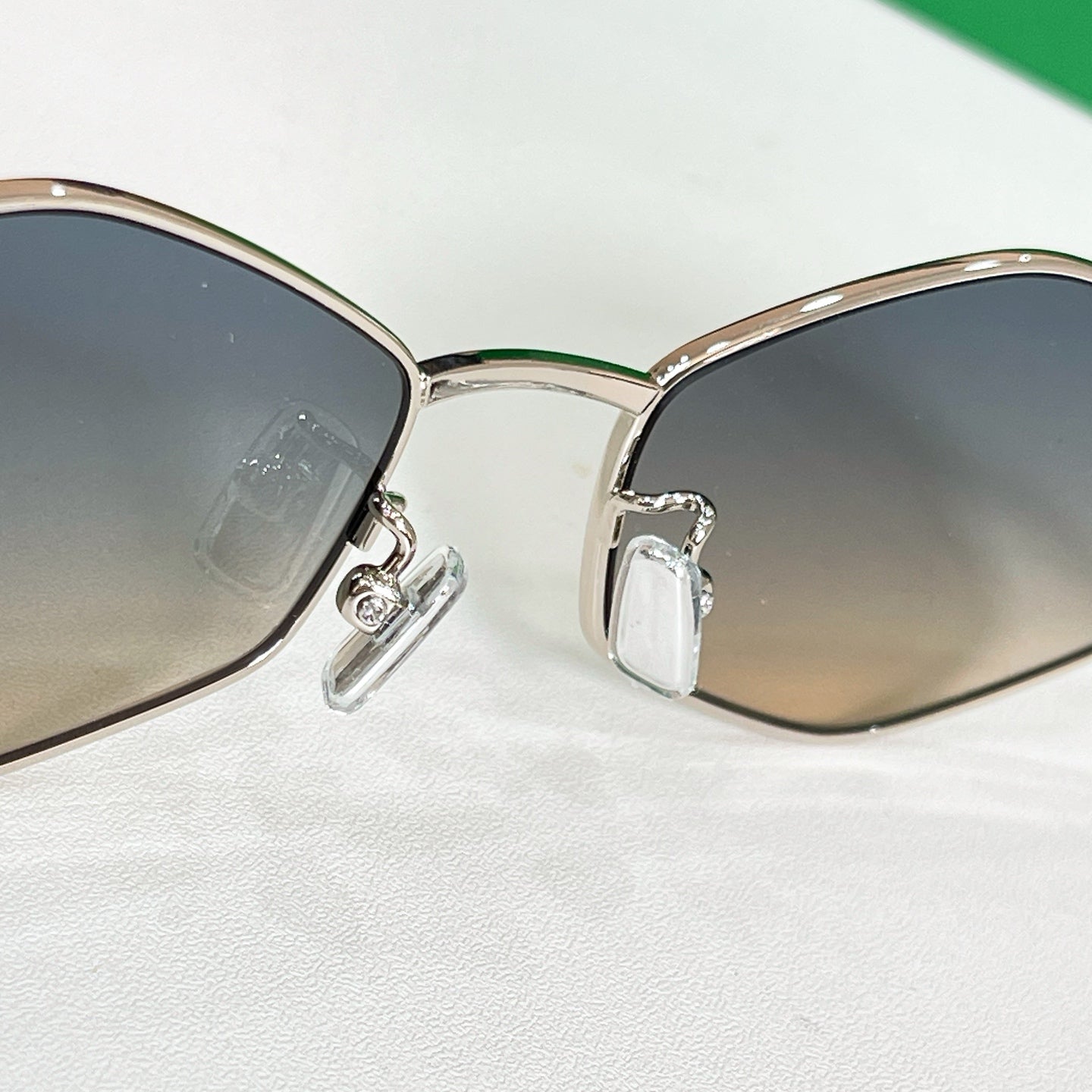 Close-up of gold-tone sunglasses front with dark lenses and metal detail at hinges