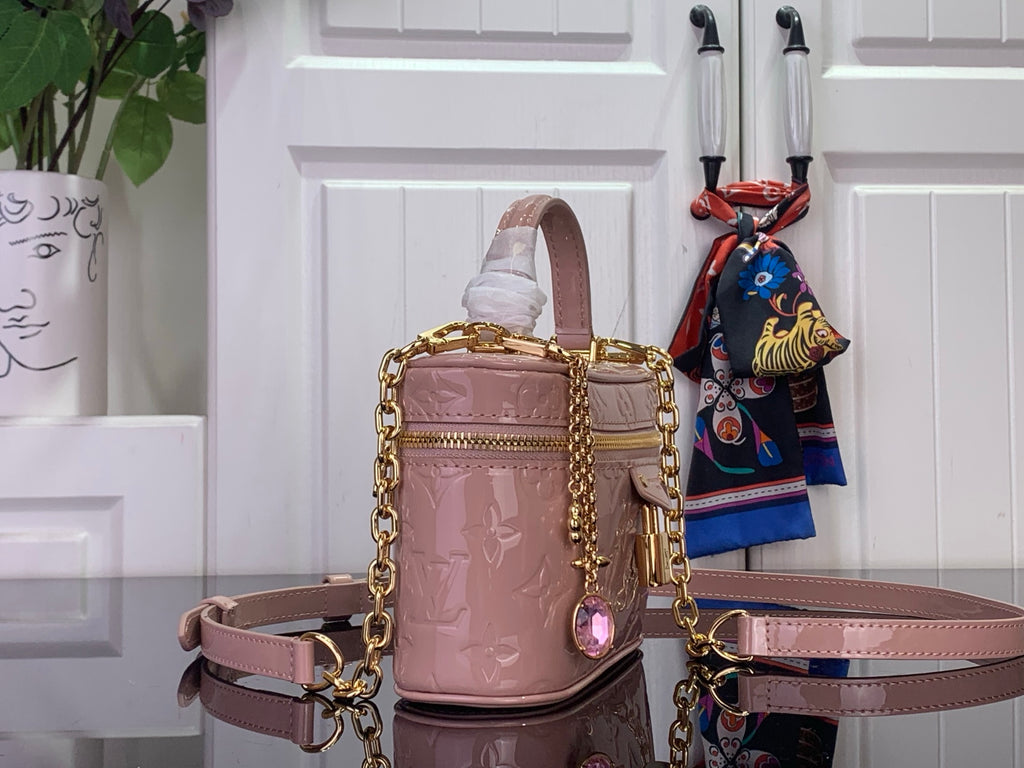 Louis Vuitton mini handbag in mauve pink with top handle, shoulder strap, and gold hardware