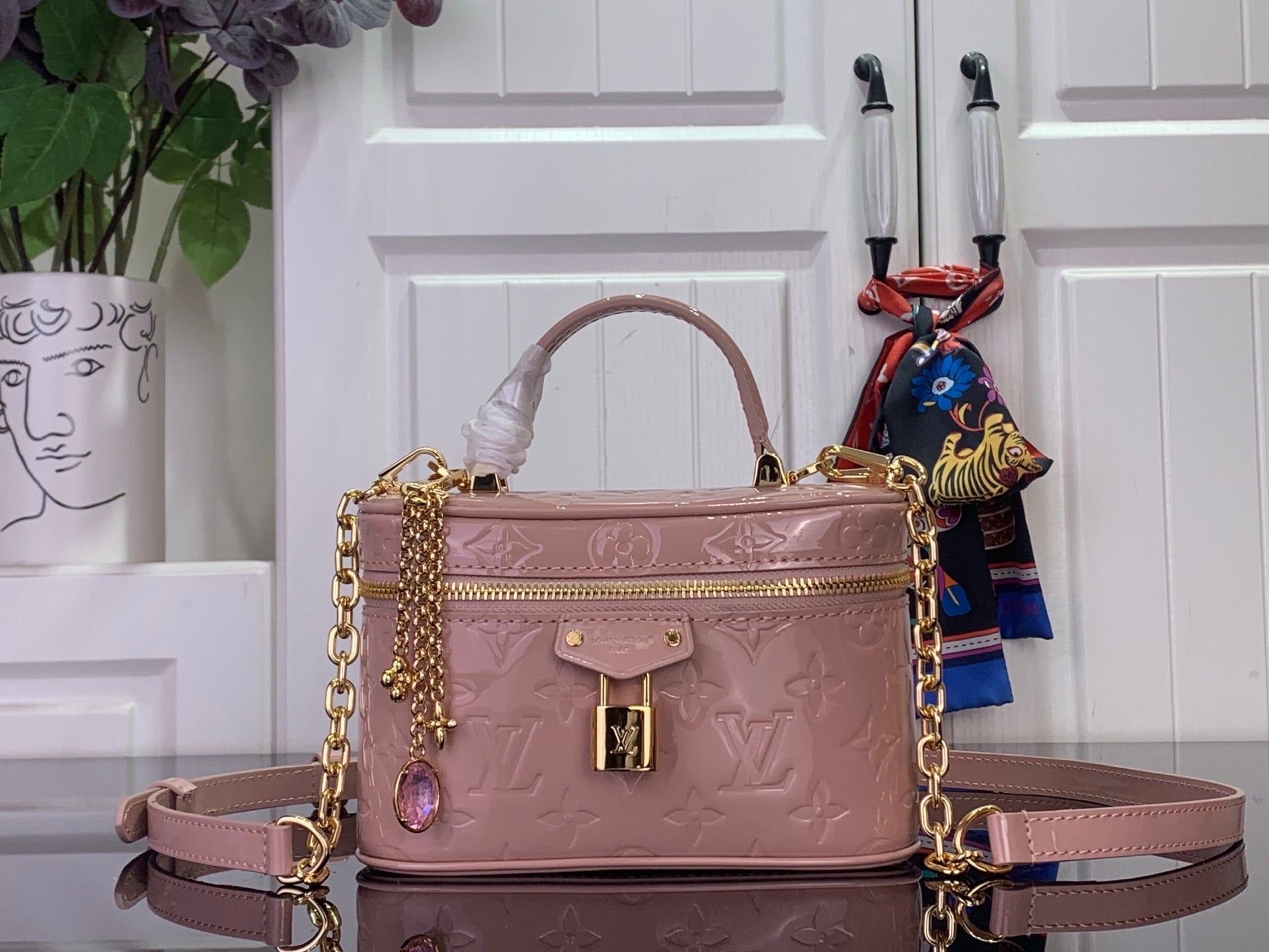 Louis Vuitton handbag in mauve pink with gold chain strap and embossed monogram finish