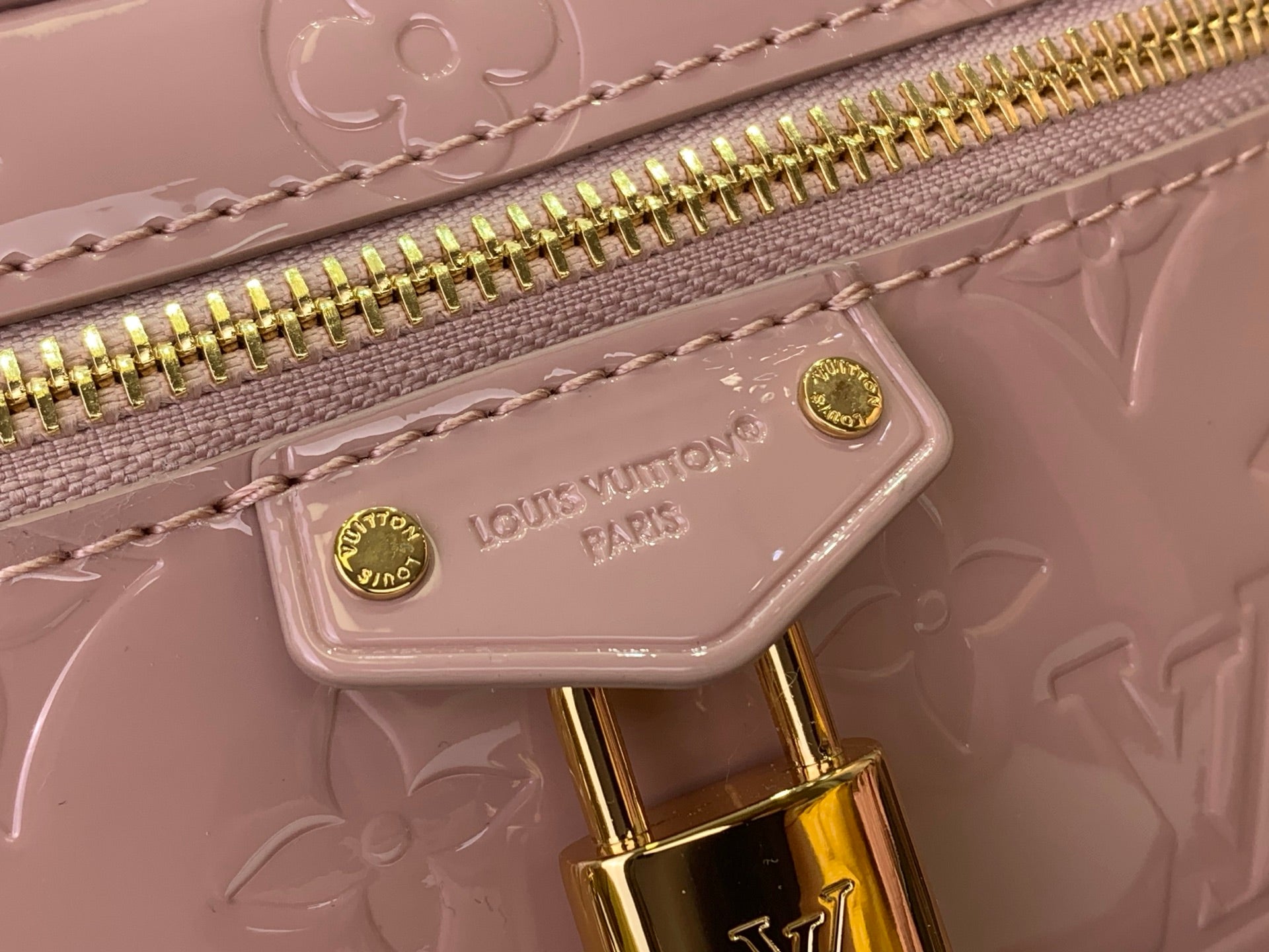 Louis Vuitton zipper pull and logo tag on mauve pink embossed mini handbag, gold hardware