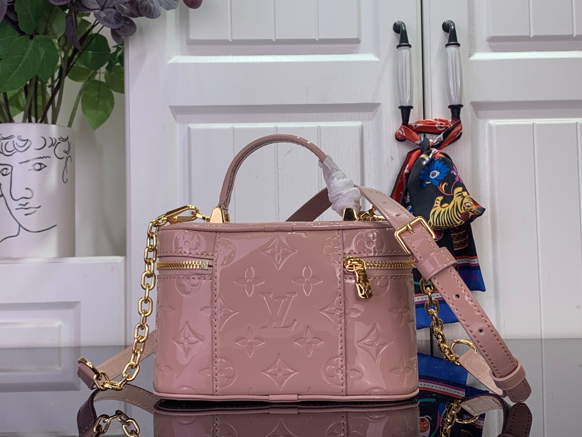 Louis Vuitton handbag in mauve pink with gold clasp, embossed monogram, and shoulder strap