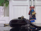 Black patent monogram handbag with wide crossbody strap and gold hardware