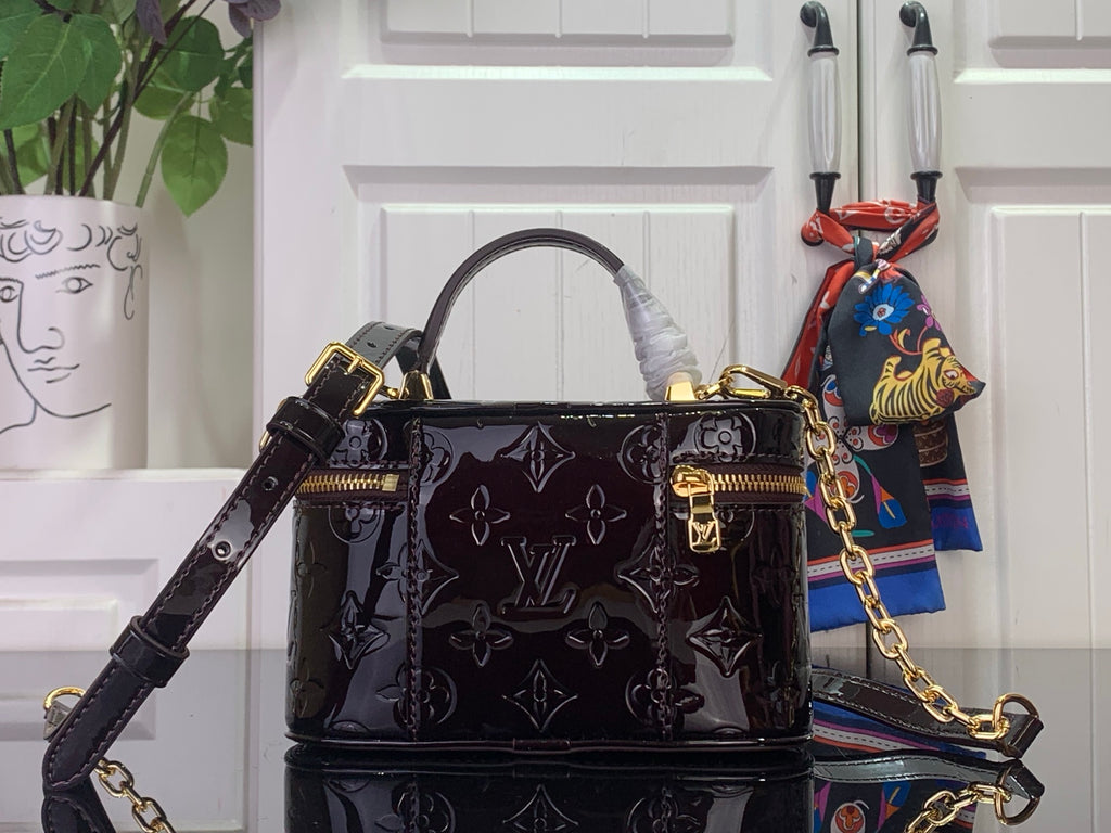 Black glossy monogram handbag with structured top handles and gold chain strap