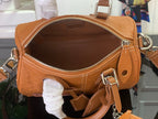 Tan leather Louis Vuitton bag opening with gold zipper, interior lining and hanging charm.