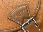 Louis Vuitton leather strap detail with engraved logo and metal buckle hardware.