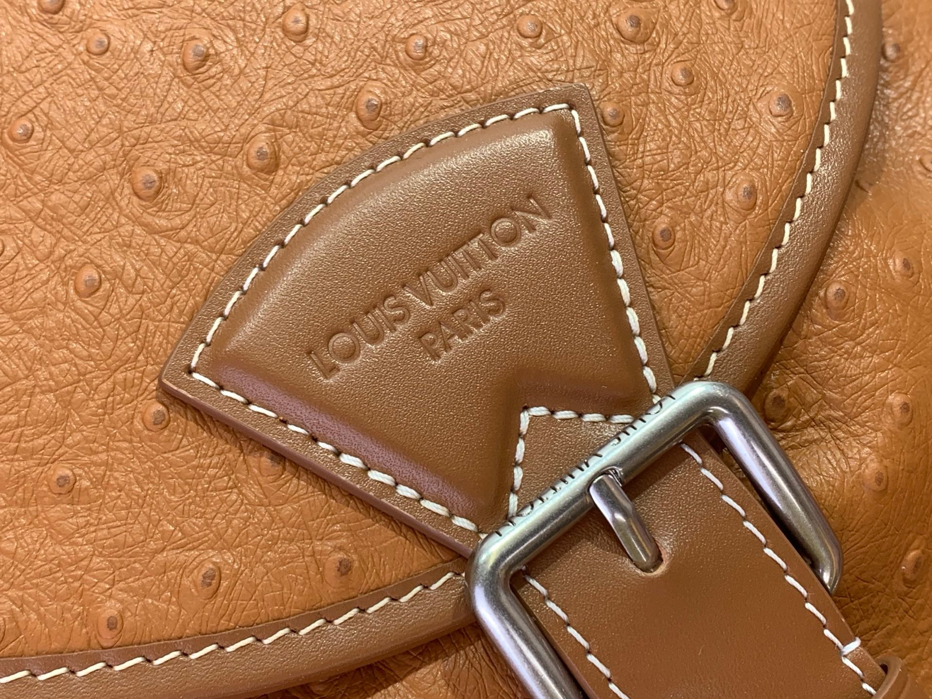 Tan leather Louis Vuitton logo patch with contrast stitching and metal D-ring hardware