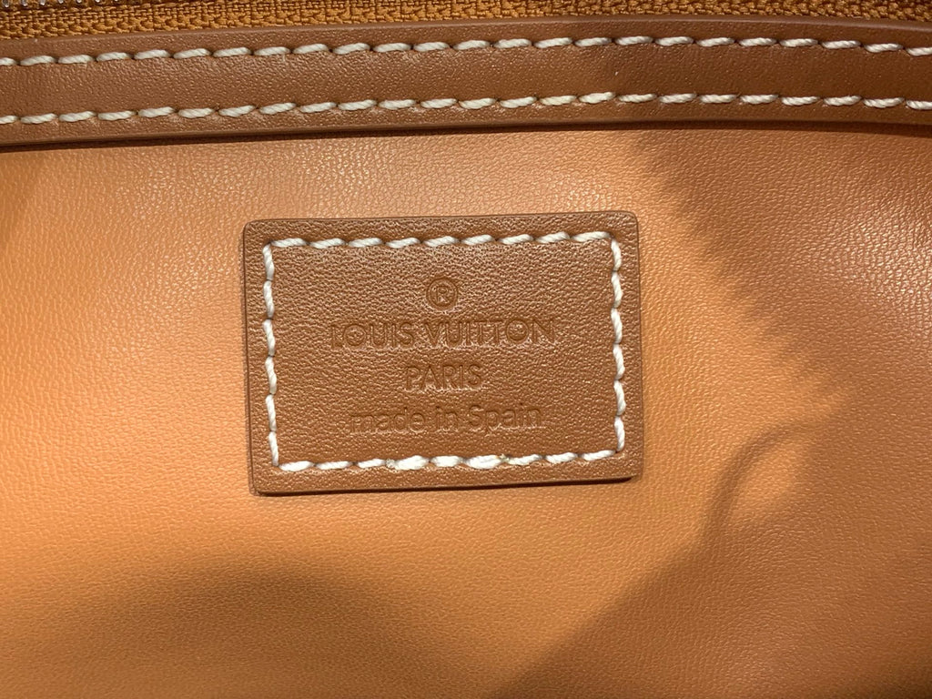 Tan Louis Vuitton leather logo patch with embossed 'LOUIS VUITTON' PARIS text.