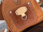 Tan leather Louis Vuitton front pocket with snap clasp and decorative hardware.