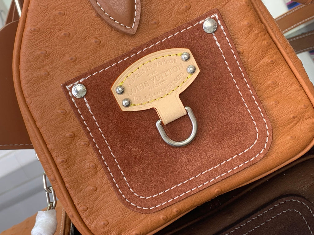 Tan leather handbag with front lock clasp and stitched border pocket detail