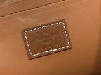Louis Vuitton leather logo patch with stitched border on tan leather.