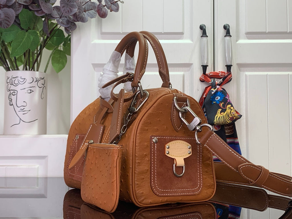 Tan leather Louis Vuitton satchel with top handle, shoulder strap and front lock plaque.