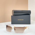 Sunglasses with gold-tone frame and light beige lenses, geometric temple logo detail.