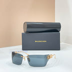Sunglasses with gold-tone frame and blue-tinted lenses, geometric logo detail at temples.