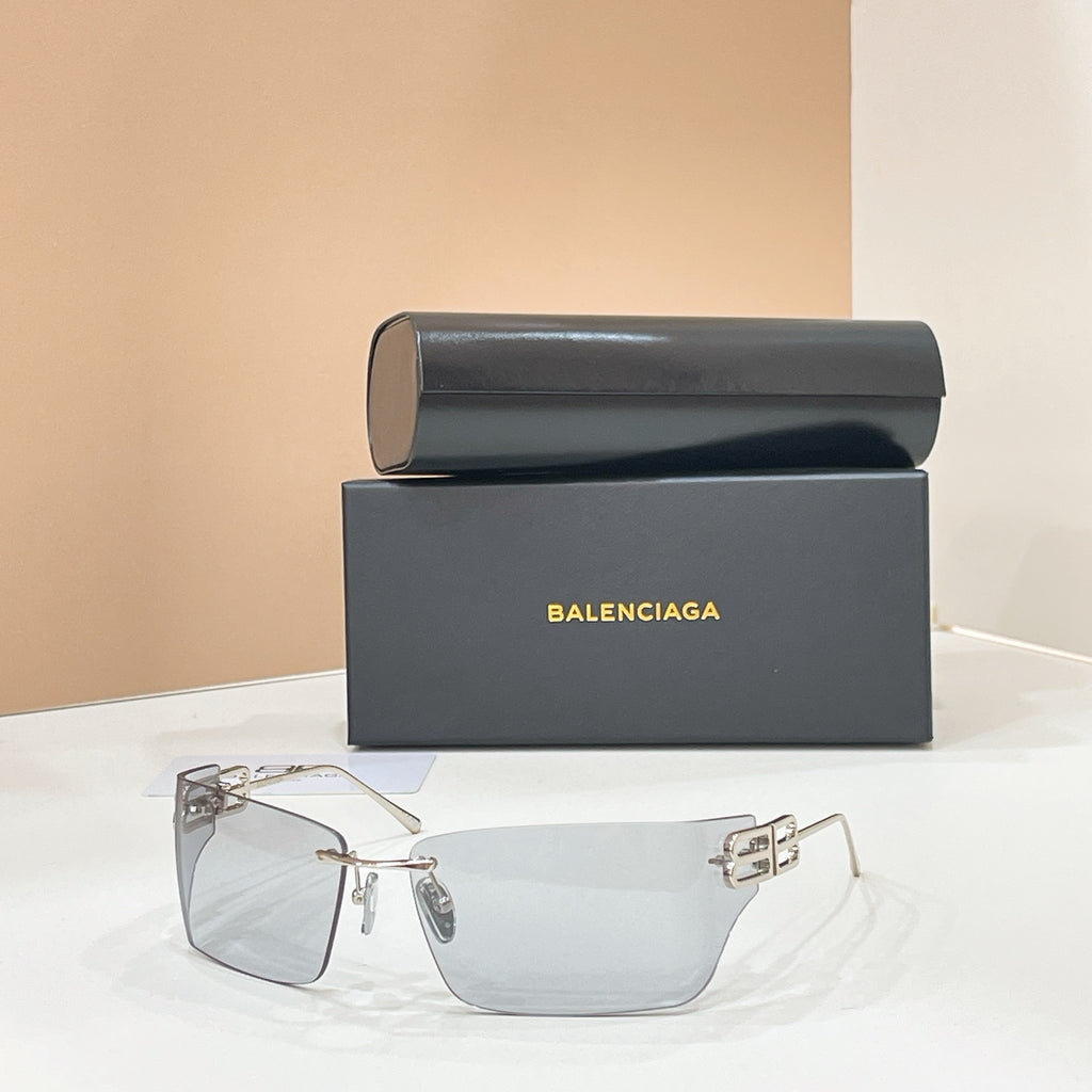 Sunglasses with gold-tone frame and clear lenses, geometric logo detail at temples.
