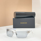 Sunglasses with gold-tone frame and clear lenses, geometric logo detail at temples.