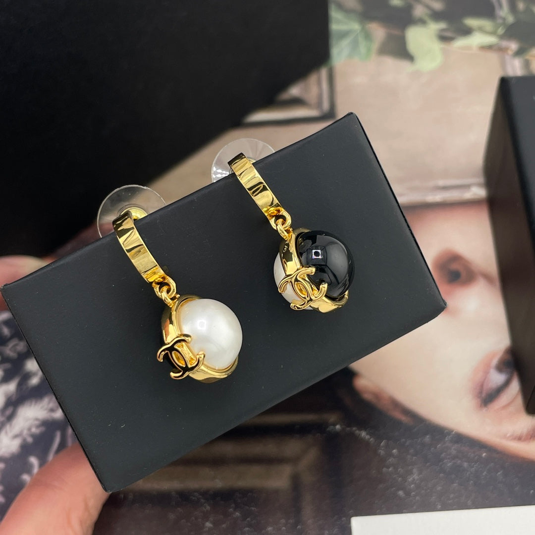 Chanel drop earrings with gold-tone hoops and dangling white and black round charms