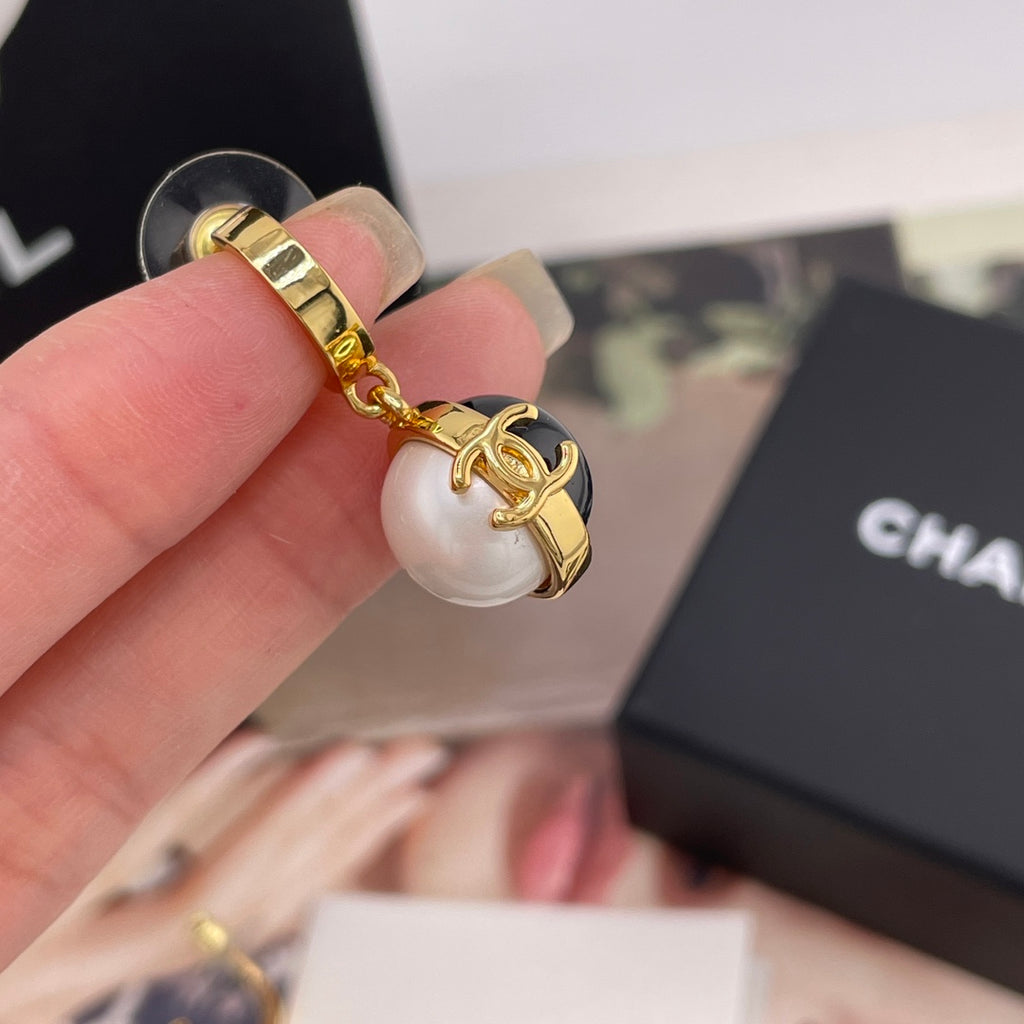 Chanel keychain style charm with gold-tone frame and black-and-white round charm