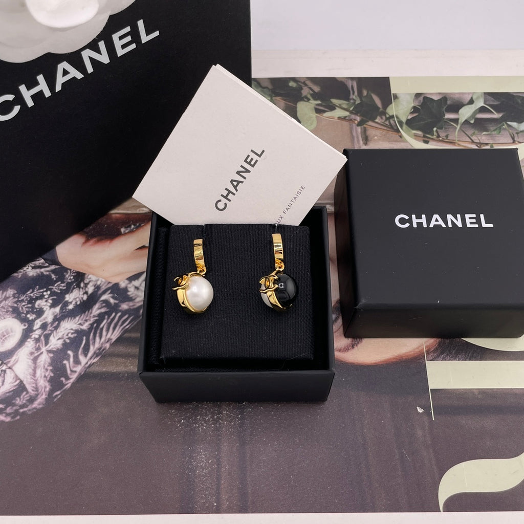 Chanel earrings set in black display box with white and black round charms
