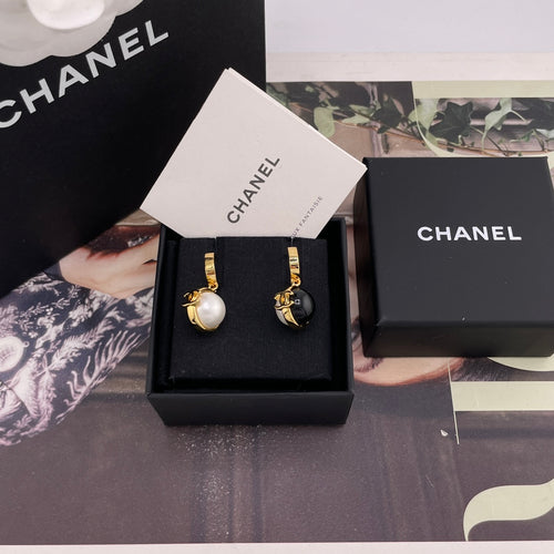 Chanel earrings set in black display box with white and black round charms