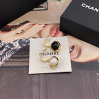 Chanel earrings with gold-tone outlines and dangling black and white round charms