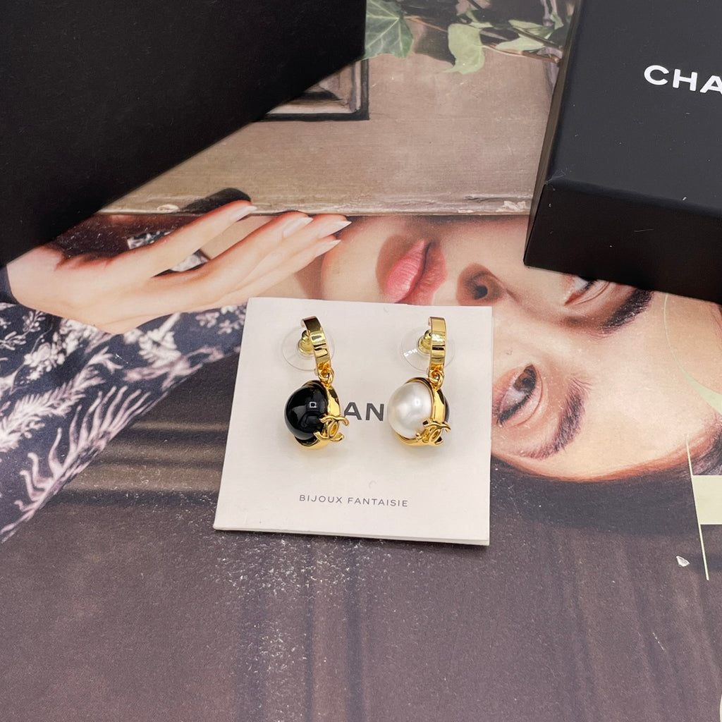 Chanel earrings shown with black and white round charms and gold-tone hoops