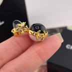 Chanel charm with gold-tone hook and black round bead with glossy finish
