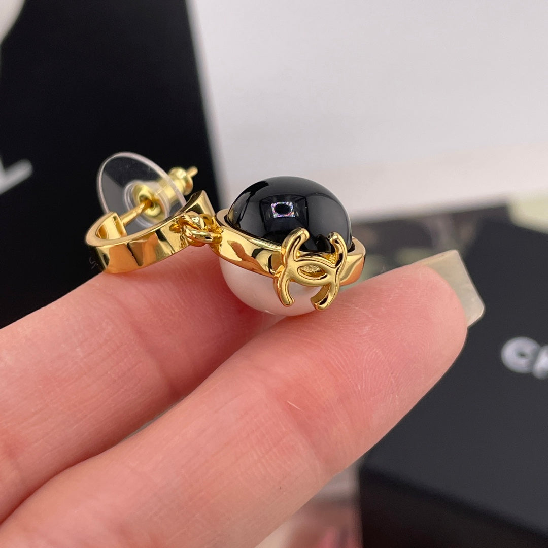 Chanel charm with gold-tone hook and black round bead with glossy finish