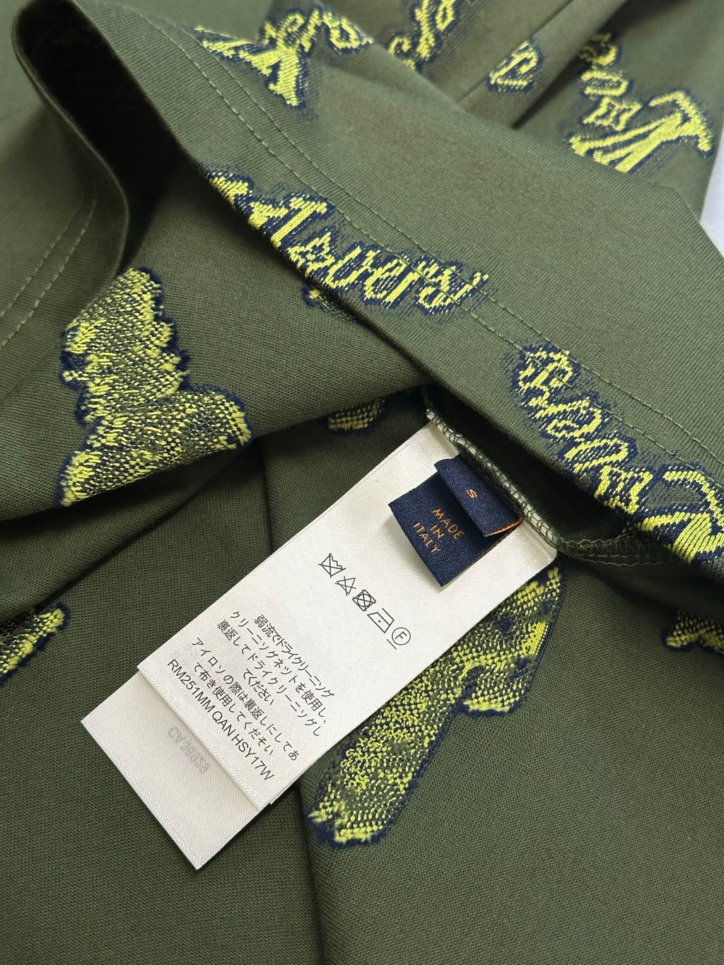 Green shirt neckline with inner tag and white care label; yellow LV-style logos