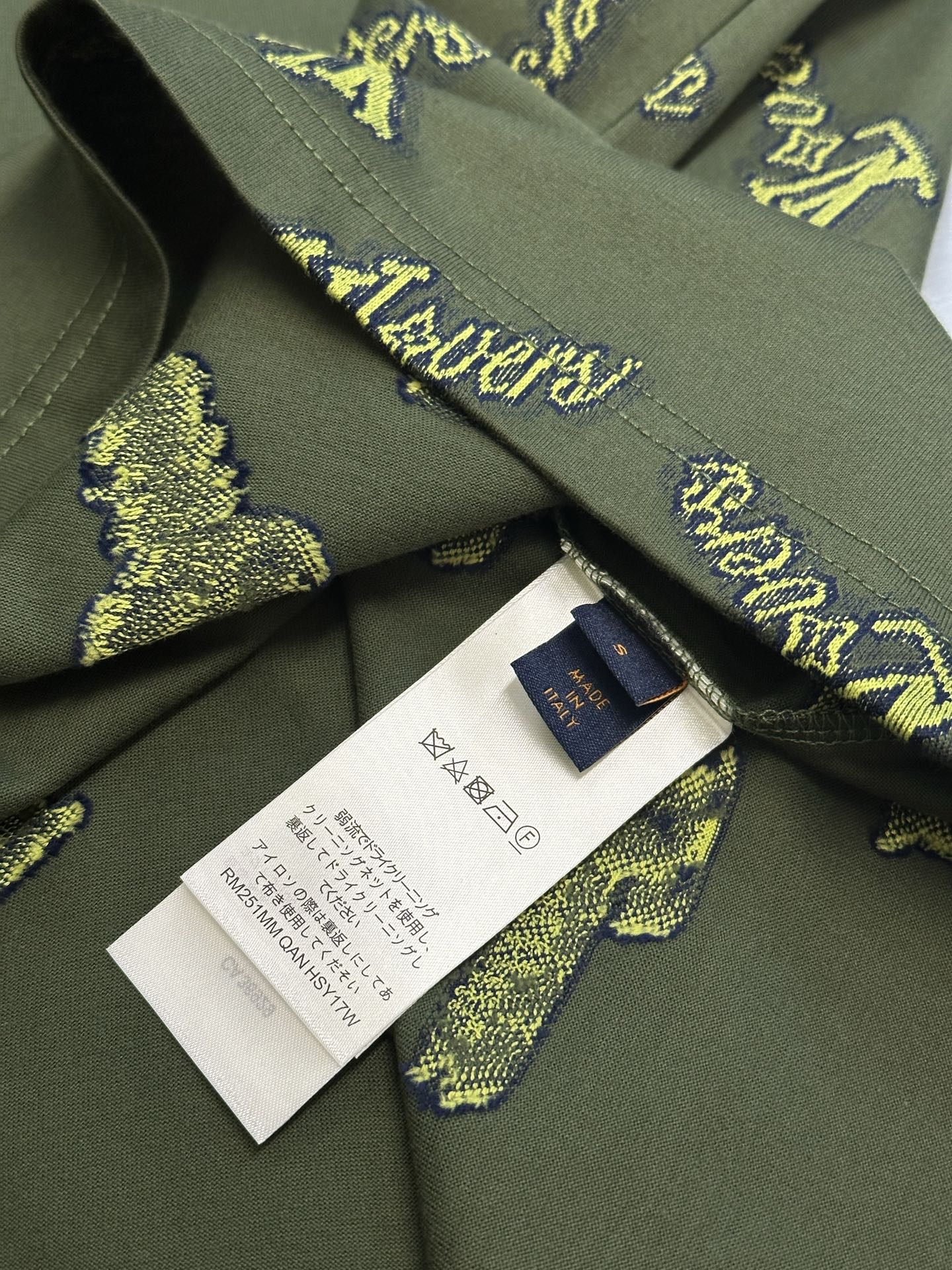 Green shirt neckline with inner tag and white care label; yellow LV-style logos