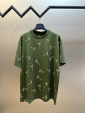 Green short-sleeve crewneck shirt with scattered yellow LV-style logo embroidery