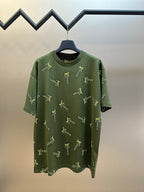 Green short-sleeve crewneck shirt with scattered yellow LV-style logo embroidery
