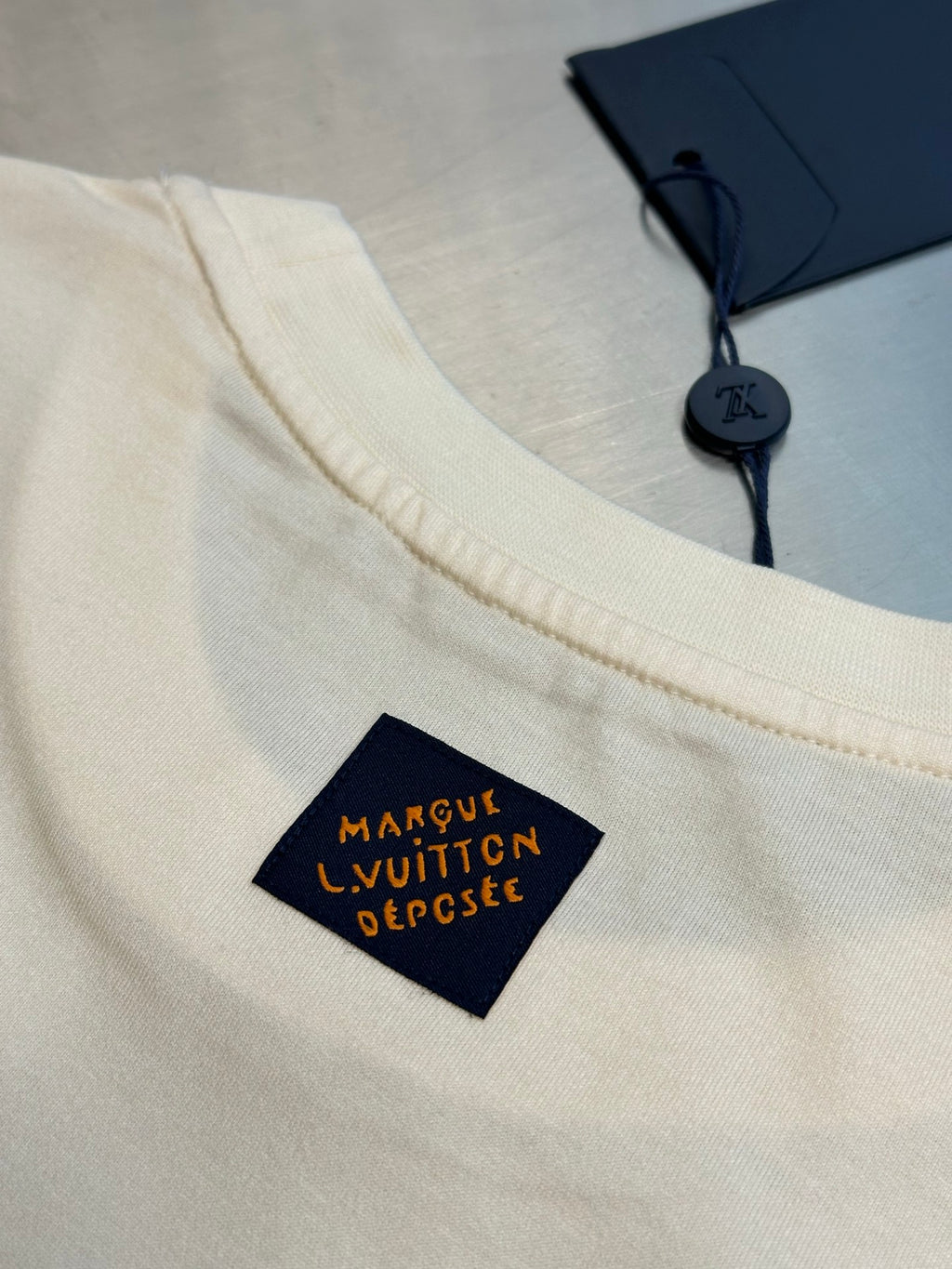 Louis Vuitton T-shirt with navy logo label at chest, cream fabric