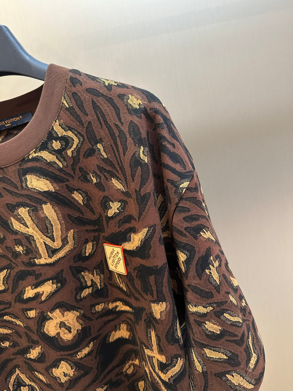 Louis Vuitton short-sleeve top sleeve close-up in dark brown with gold allover pattern