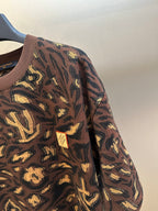 Louis Vuitton short-sleeve top sleeve close-up in dark brown with gold allover pattern
