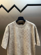 Beige monogram short-sleeve T-shirt hanging on a blue hanger