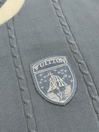 Close-up of Louis Vuitton shield logo badge on light blue knit polo