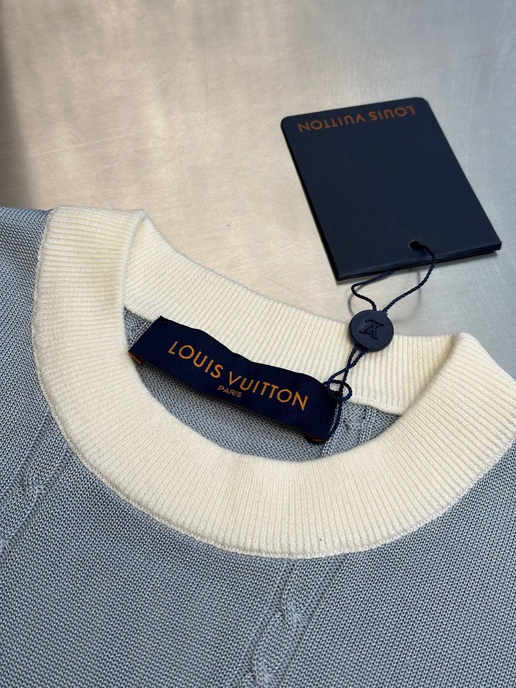 Light blue knit polo collar with off-white ribbing and Louis Vuitton label