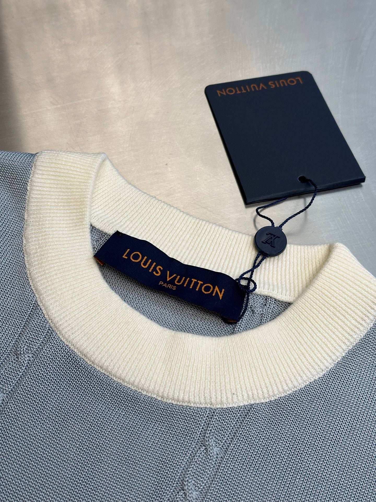 Light blue knit polo collar with off-white ribbing and Louis Vuitton label