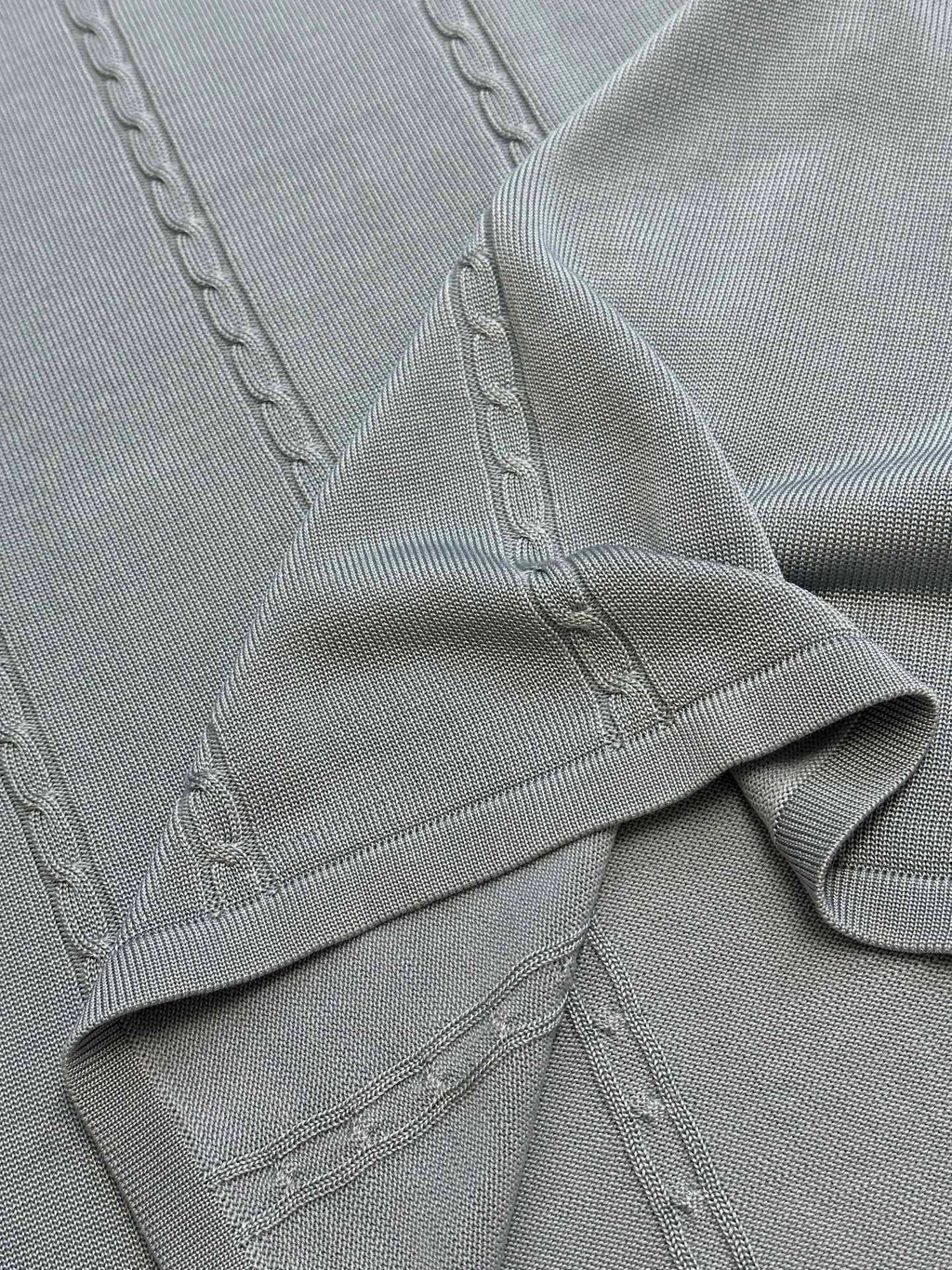 Light blue knit polo placket with stitched details and ribbed hem
