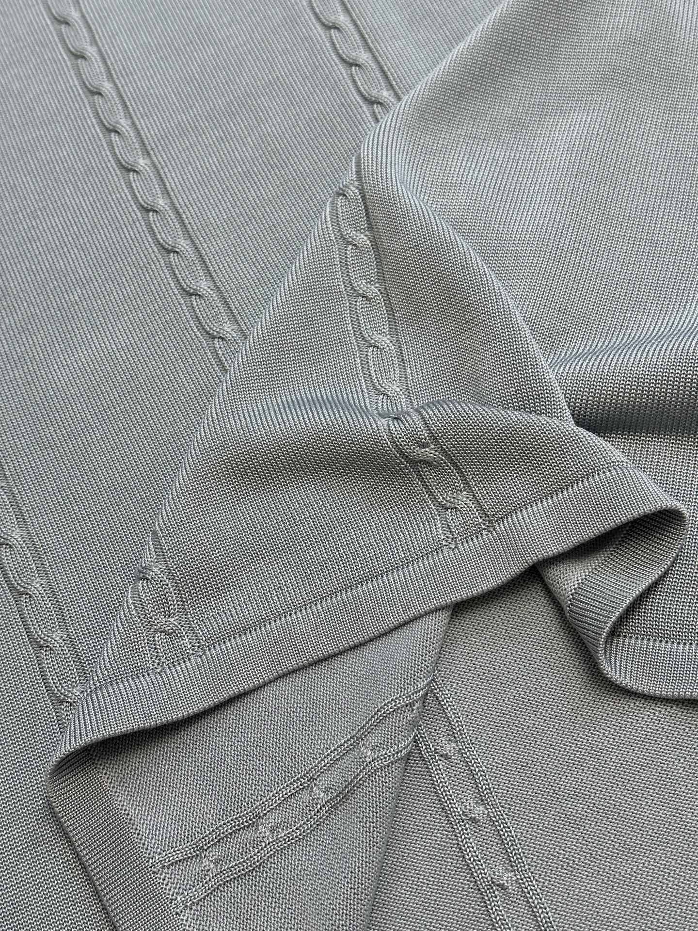 Light blue knit polo placket with stitched details and ribbed hem